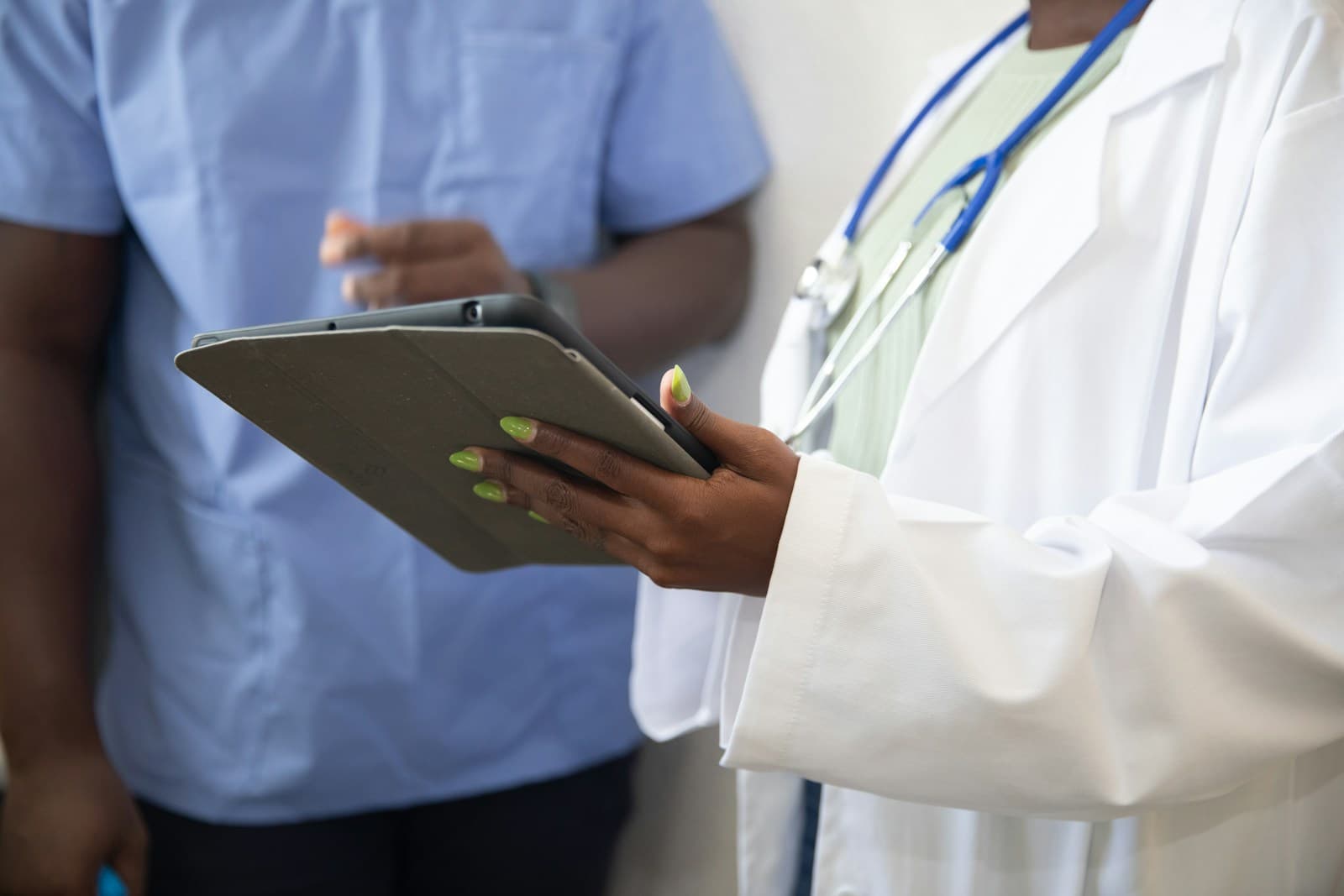Primary care doctor reviewing a patient's chronic care plan in a clinic exam room