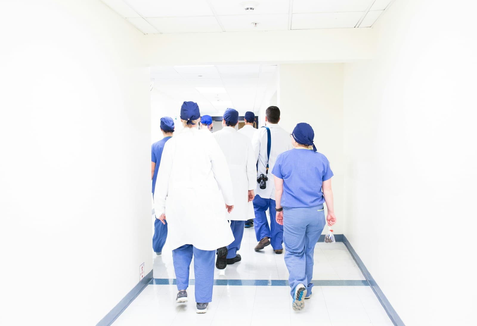 Hospital care team walking a facility corridor while coordinating patient handoffs