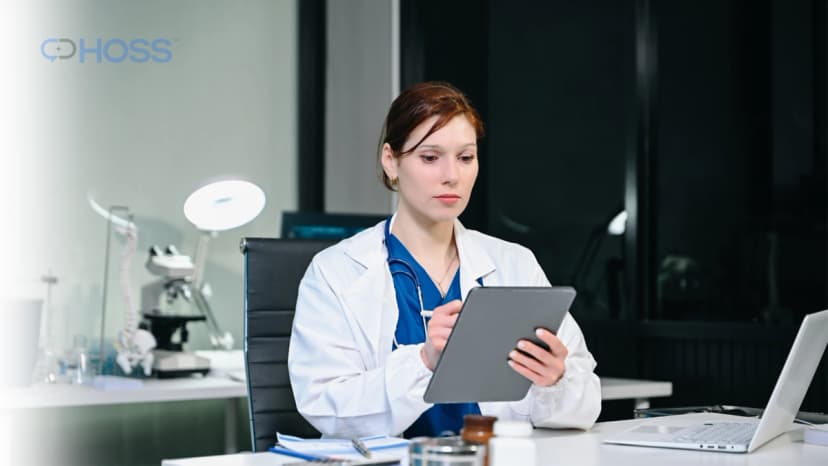 Healthcare professional reviewing remote patient monitoring information on a tablet in a clinical setting.