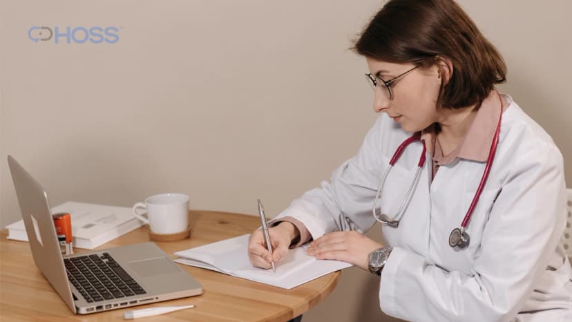 Doctor reviewing patient documentation beside a laptop for Medicare care management.